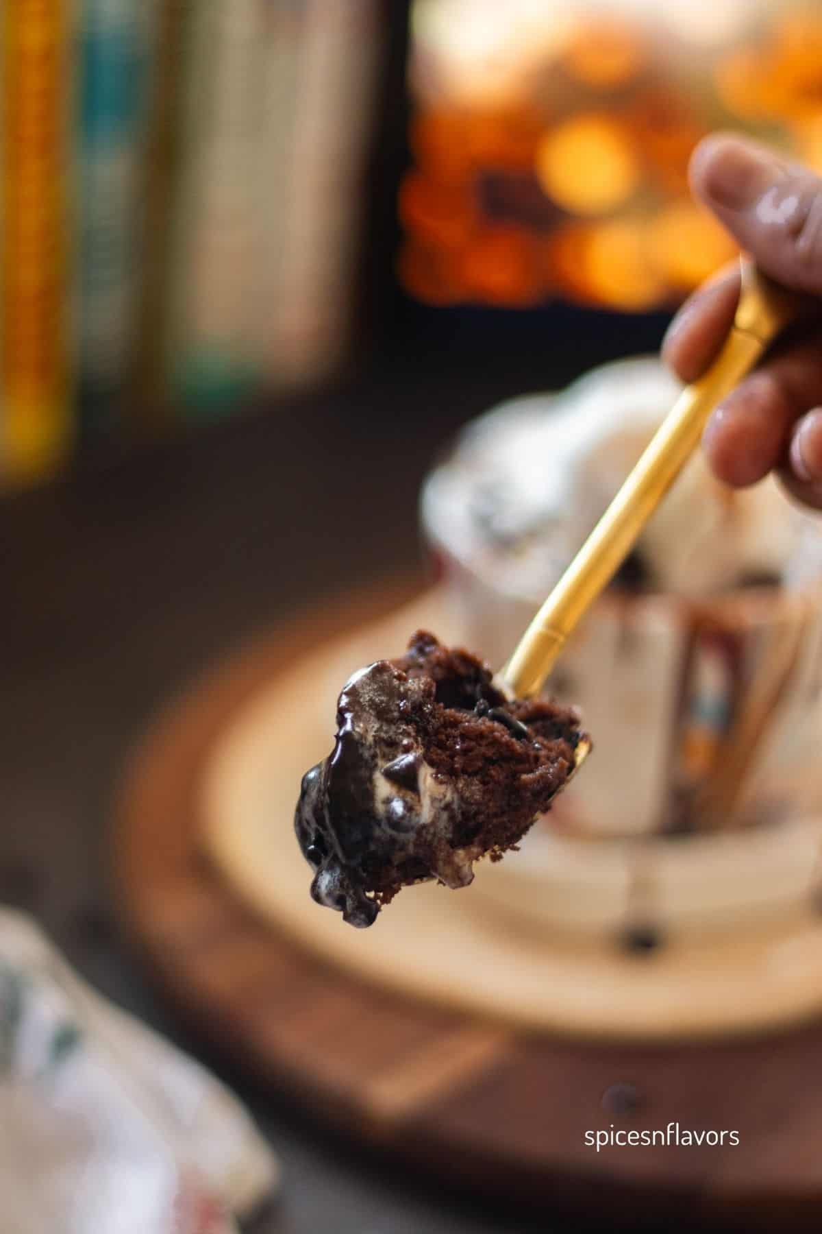 chocolate mug cake scooped out in a golden spoon