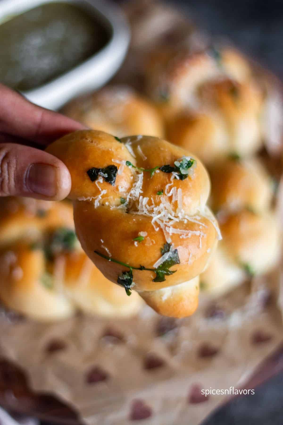 holding baked garlic knot bread in fingers