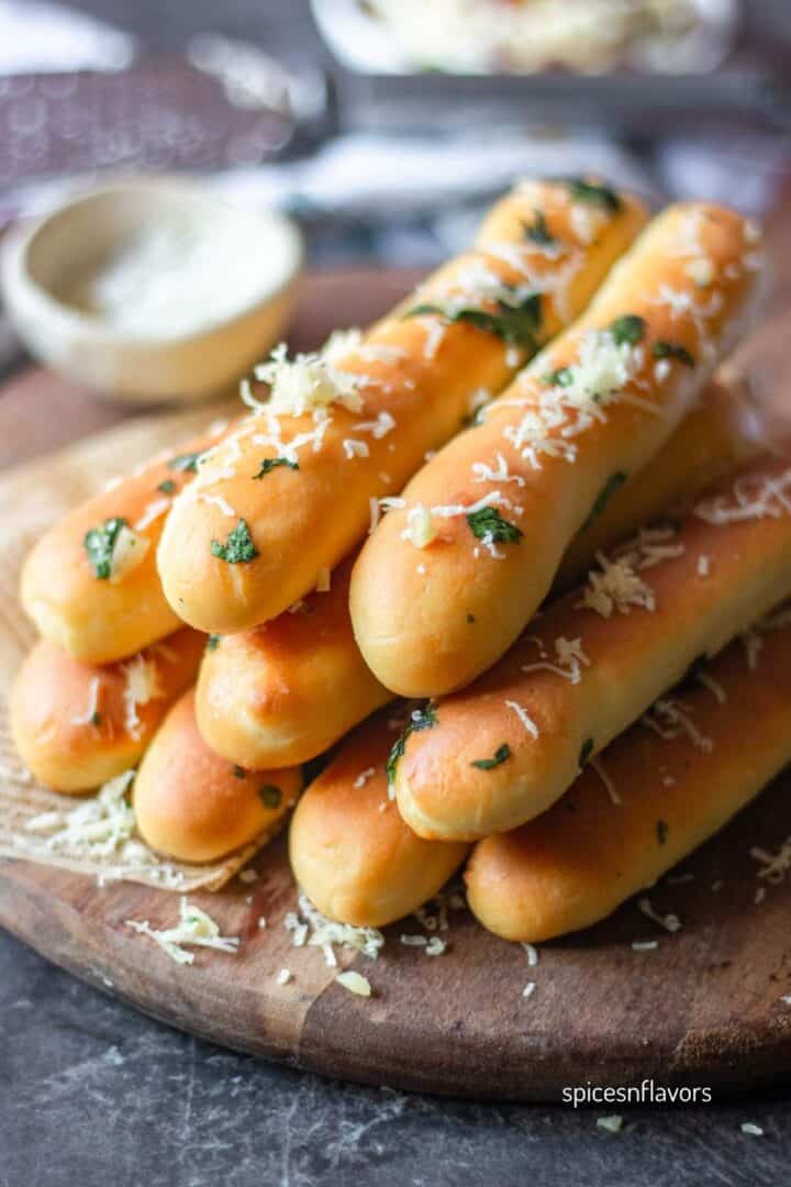 stacked garlic breadsticks with parmesan cheese sprinkled on top